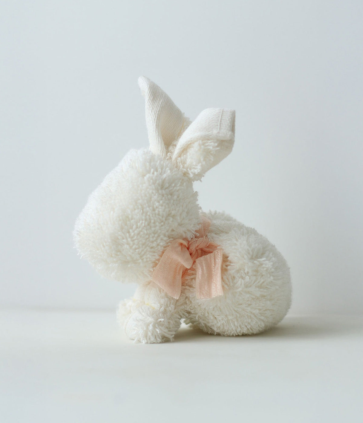 Hase aus weißem Frottier mit hellrosa Masche.