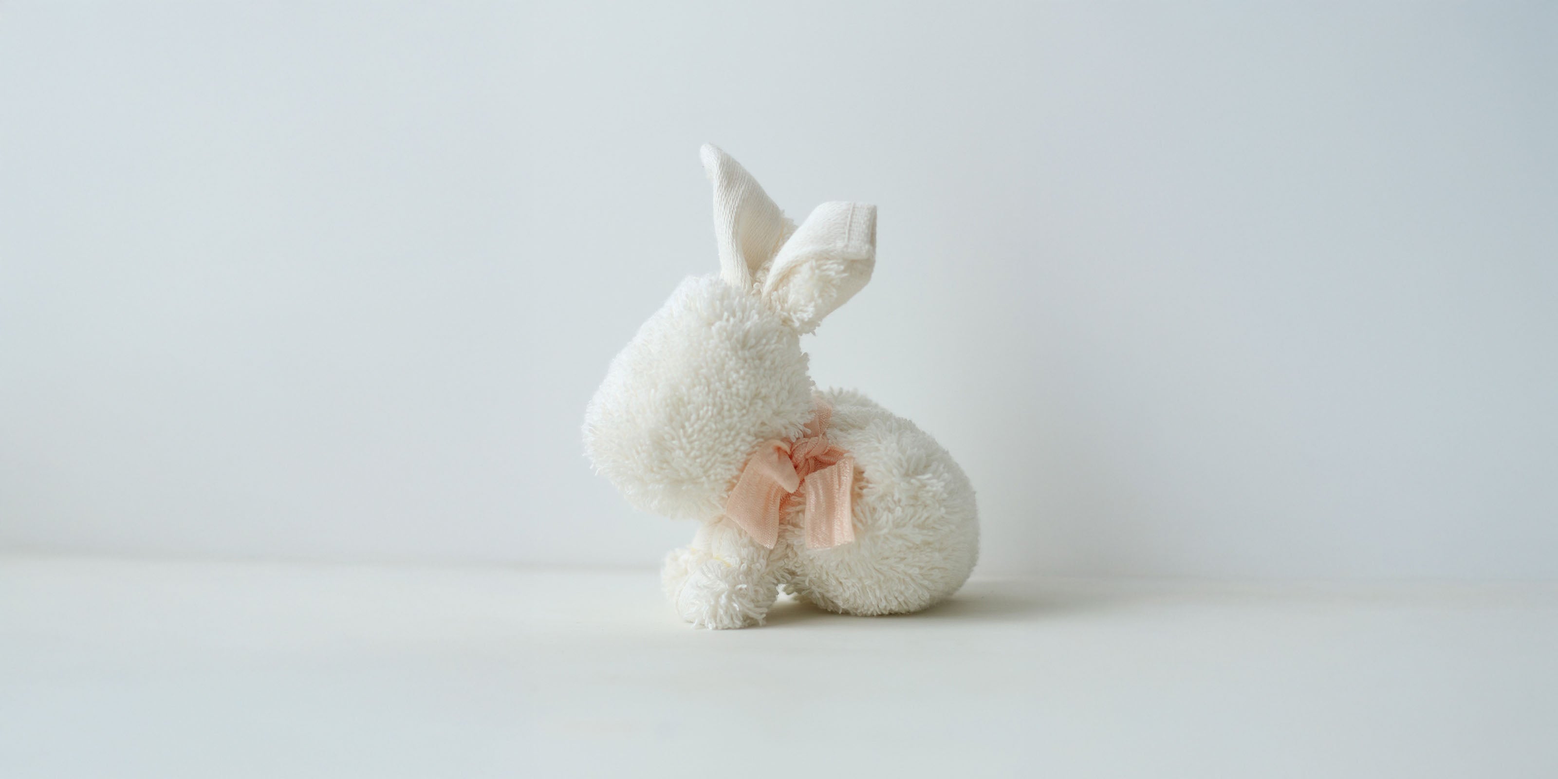 Hase aus weißem Frottier mit hellrosa Masche.