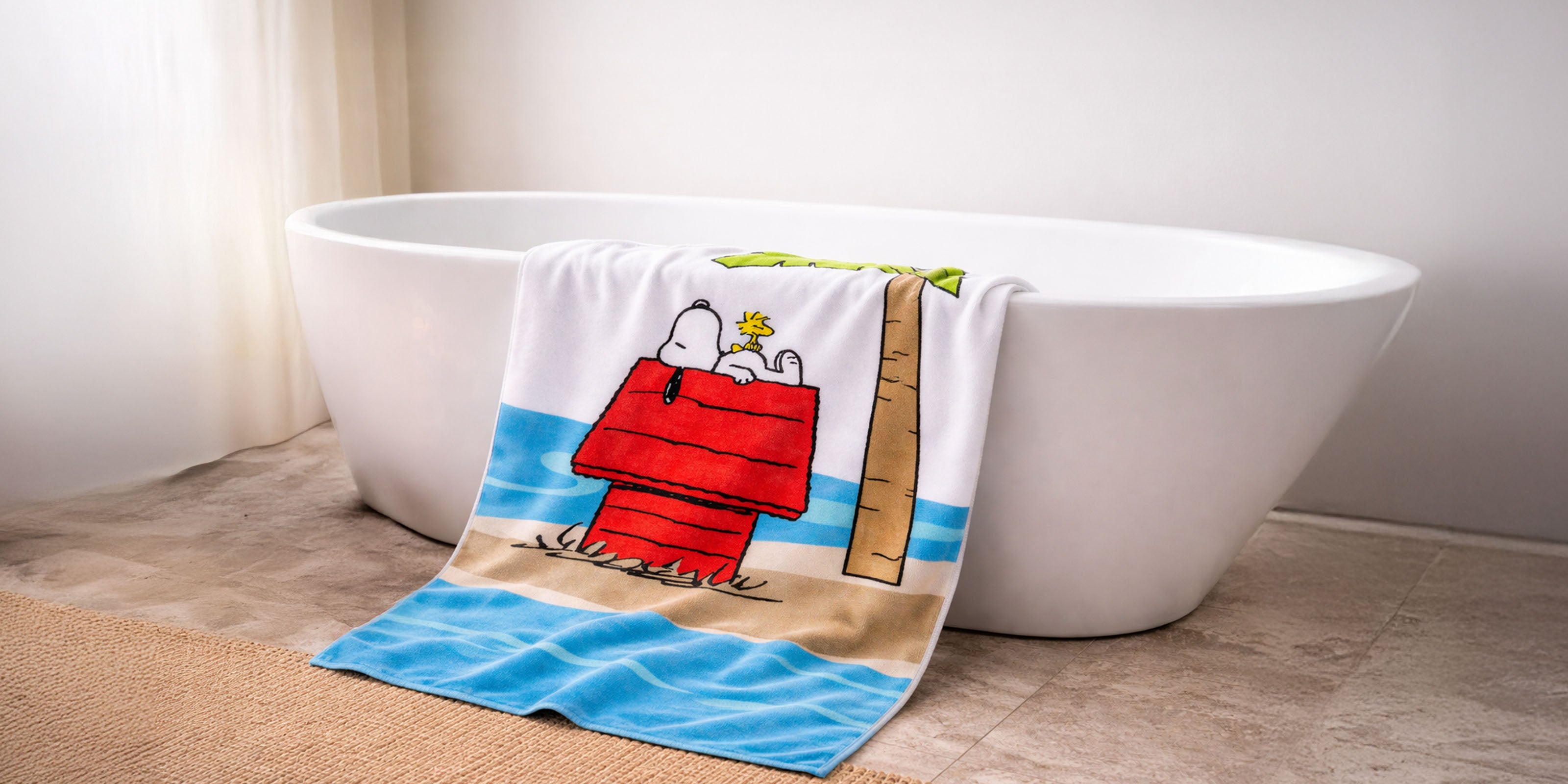 Handtuch mit Snoopy-Motiv hängt über dem Rand einer freistehenden Badewanne