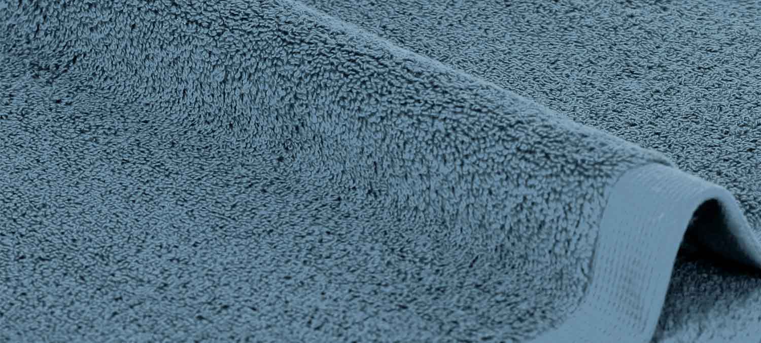 Nahaufnahme eines blauen Handtuchs mit strukturierter Oberfläche und gefalteten Kanten.
