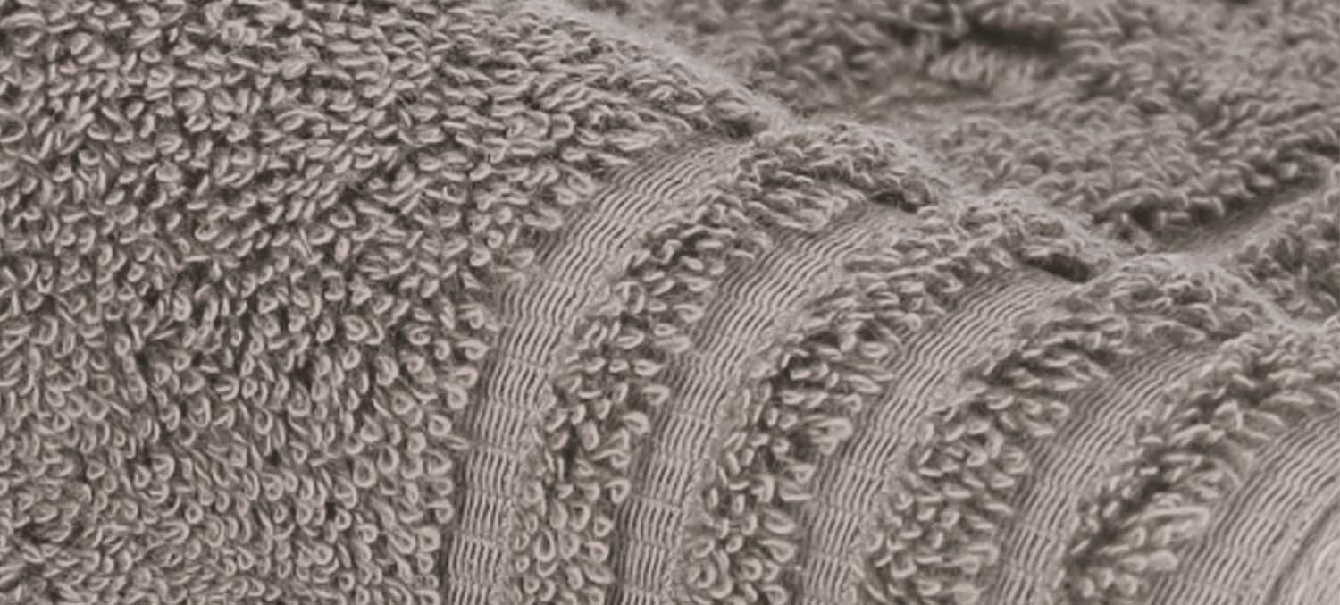 Nahaufnahme eines strukturierten grauen Handtuchs mit Schlaufen und Streifenmuster.