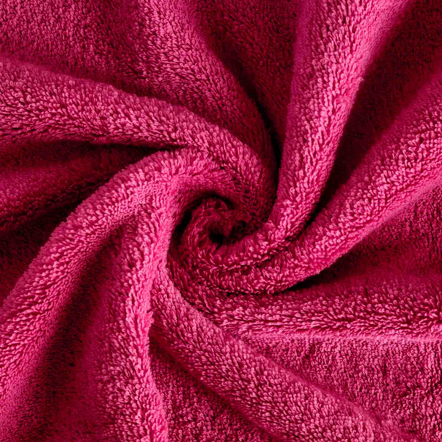 Pinkes Frottierhandtuch in Vogelperspektive eingedreht in einen Wirbel.