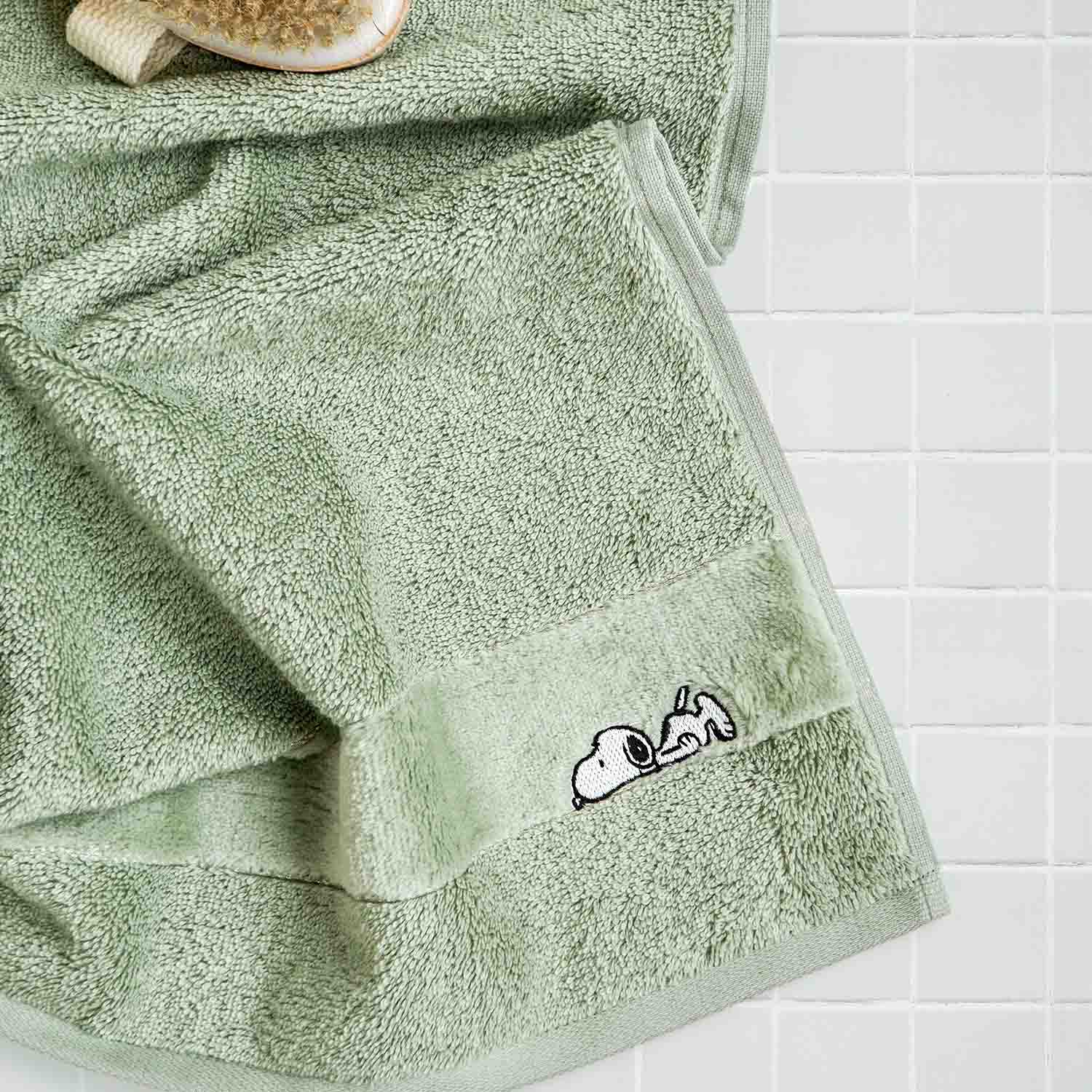 Hellgrünes Handtuch mit gesticktem Snoopy-Motiv aus der VOSSEN x Peanuts Kollektion – weiche Baumwolle für stilvolle Bade- und Wellnessmomente.