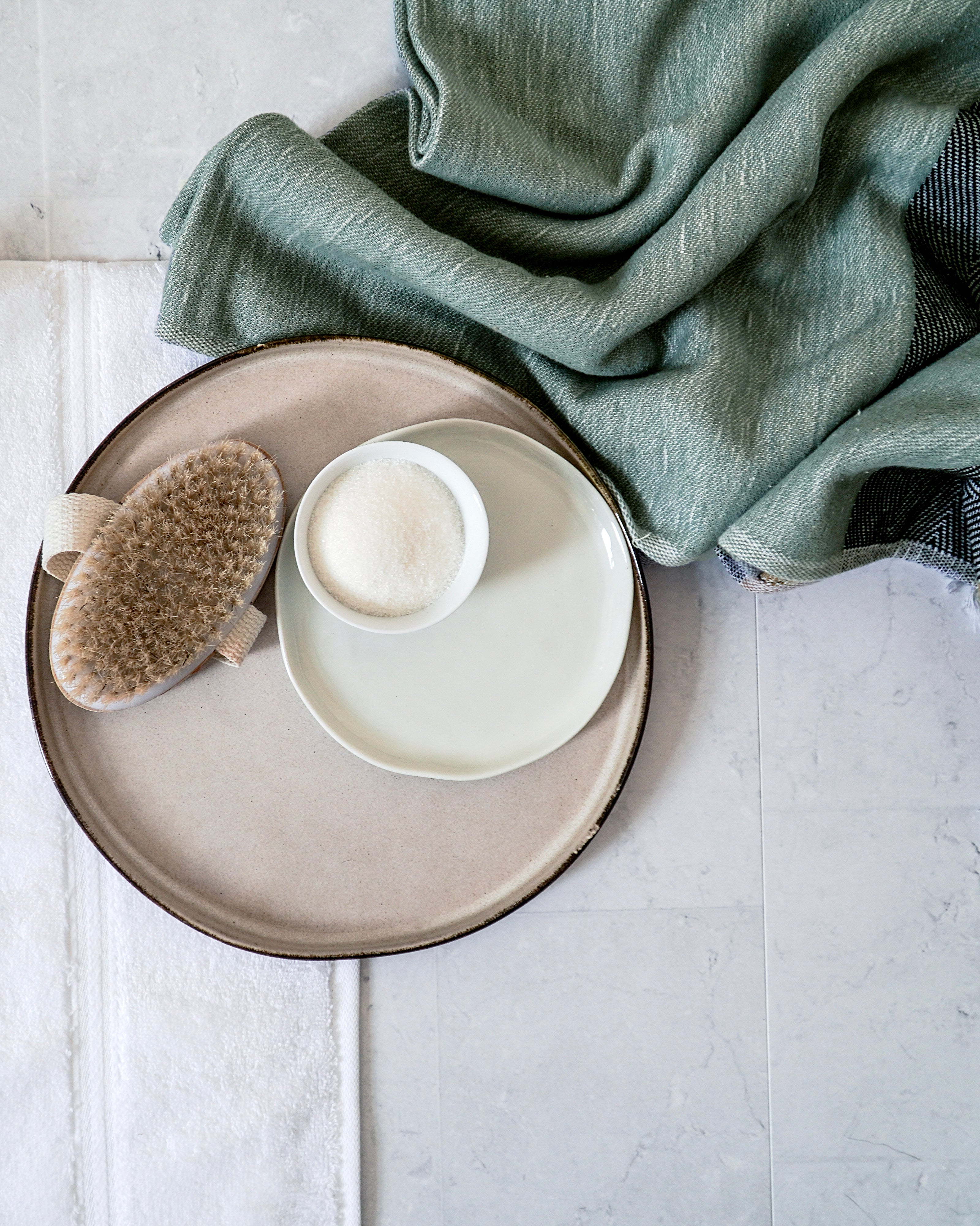 Seifenschale, Bürste und grünes Handtuch auf einem Tablett im Bad